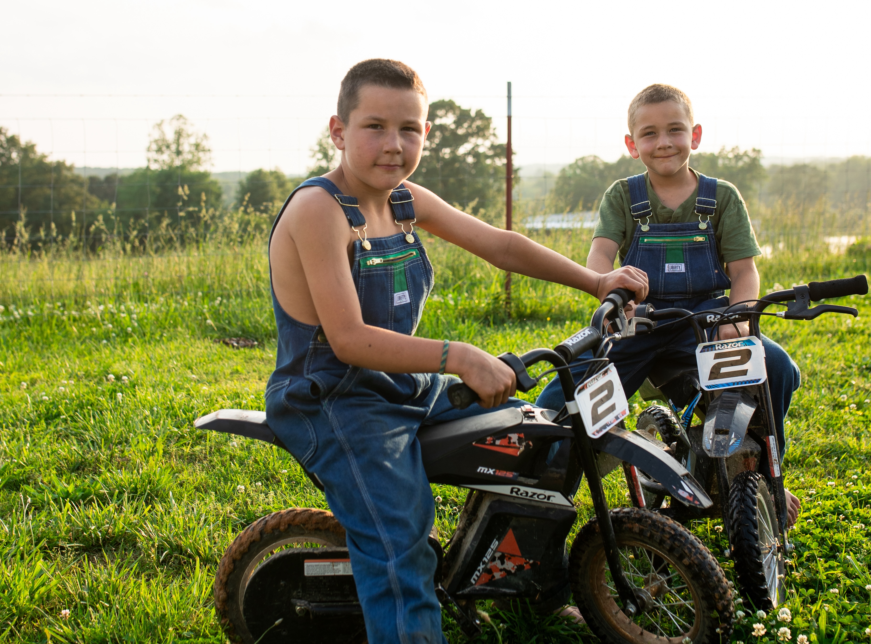 Two farmers in a field with Liberty Bib Overalls on